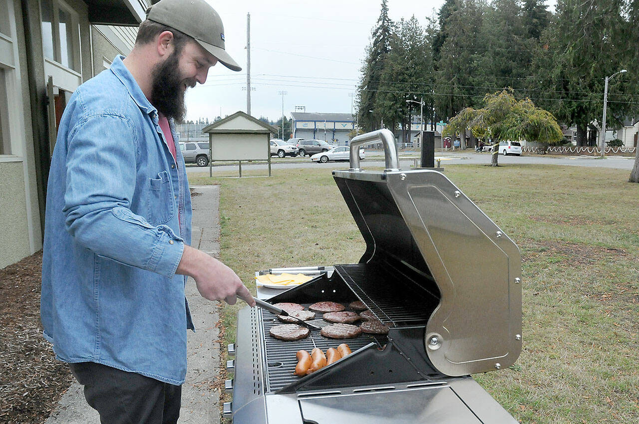Levi Douglas, Clallam County Veterans program coordinator and U.S. Air Force veteran, cooks burgers and hot dogs during a Veterans Day barbecue for vets and their families at the Clallam County Veterans Center in Port Angeles. The event was one of several across the North Olympic Peninsula honoring those who served their country. (Keith Thorpe/Peninsula Daily News)