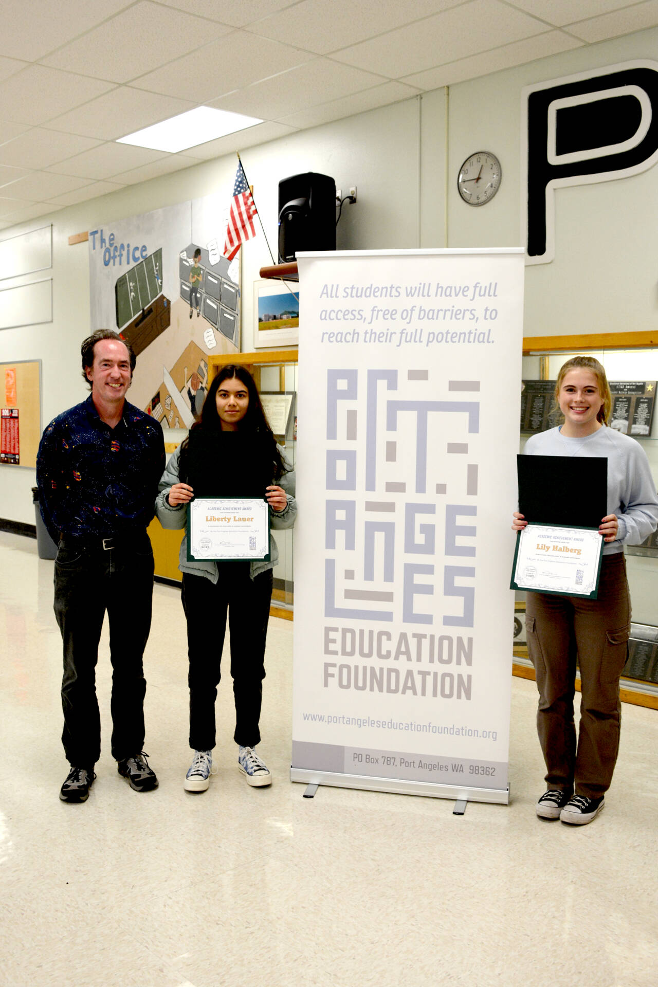 Port Angeles High School Honor Society Advisor John Gallagher, left, poses with Port Angeles Education Academic Achievement Award recipients Liberty Lauer and Lily Halberg.