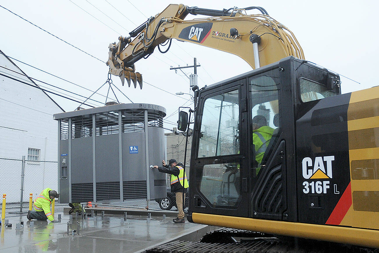 KEITH THORPE/PENINSULA DAILY NEWS
A prefabricated Portland Loo public toilet is lowered into place on a pad at the edge of the Breezeway public parking lot in the 100 block of West Front Street in downtown Port Angeles on Tuesday. The unit, one of two being installed at the location, replaces the original concrete block public restroom that previously occupied the site, with a third slated for The Gateway transit center. The new facilities are ADA-compliant, require no winterization and will be open to the public 24 hours a day, seven days a week.