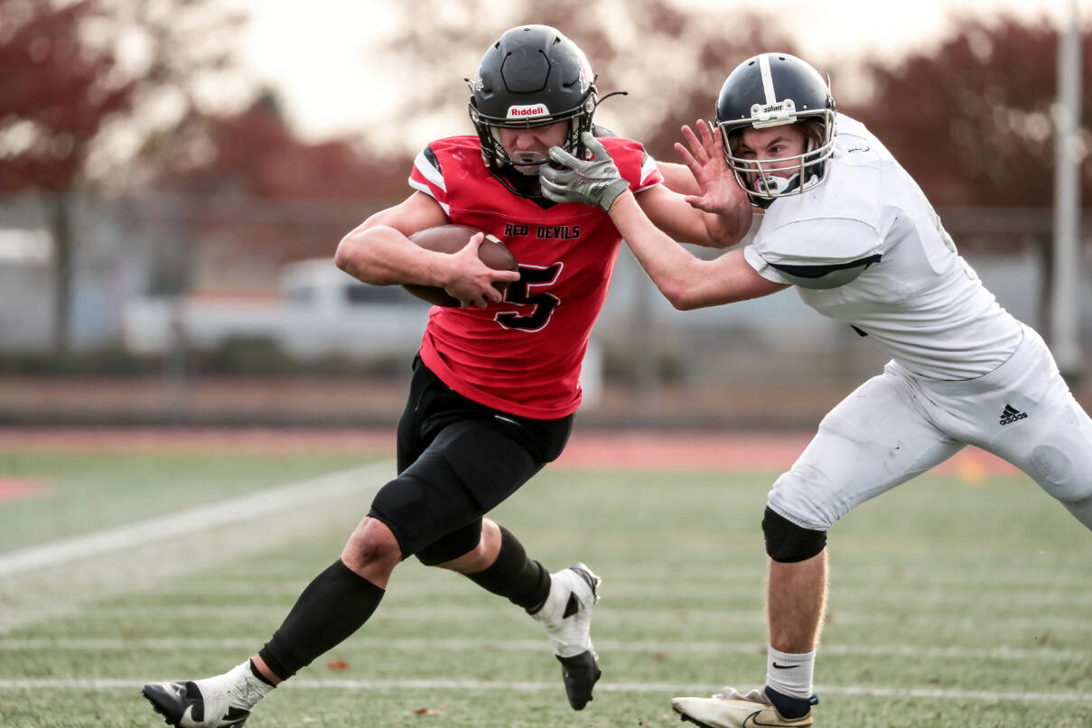 Maria Dorsten/for Peninsula Daily News
Neah Bay quarterback Julian Carrick is facemasked by a Liberty Christian defender on one of his big runs Saturday in the state 1B semifinals held at Mount Tahoma High School in Tacoma. Carrick scored six touchdowns as Neah Bay won 82-24. The Red Devils will face Liberty Bell next week in the championship game.