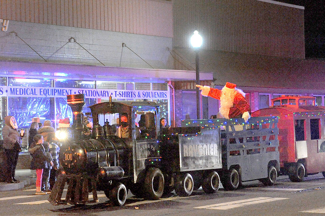 Santa tides down Forks Avenue in the West End Business Professional Association train on Saturday evening during the 21st annual Twinkle Light Parade before lighting the Forks Community Tree at the intersection of Sol Duc Way and Forks Avenue. Before and after the parade, the public viewed the Soroptimist International of the Olympic Rain Forest’s annual Festival of Trees. Trees were auctioned off Sunday. (Lonnie Archibald/for Peninsula Daily News)