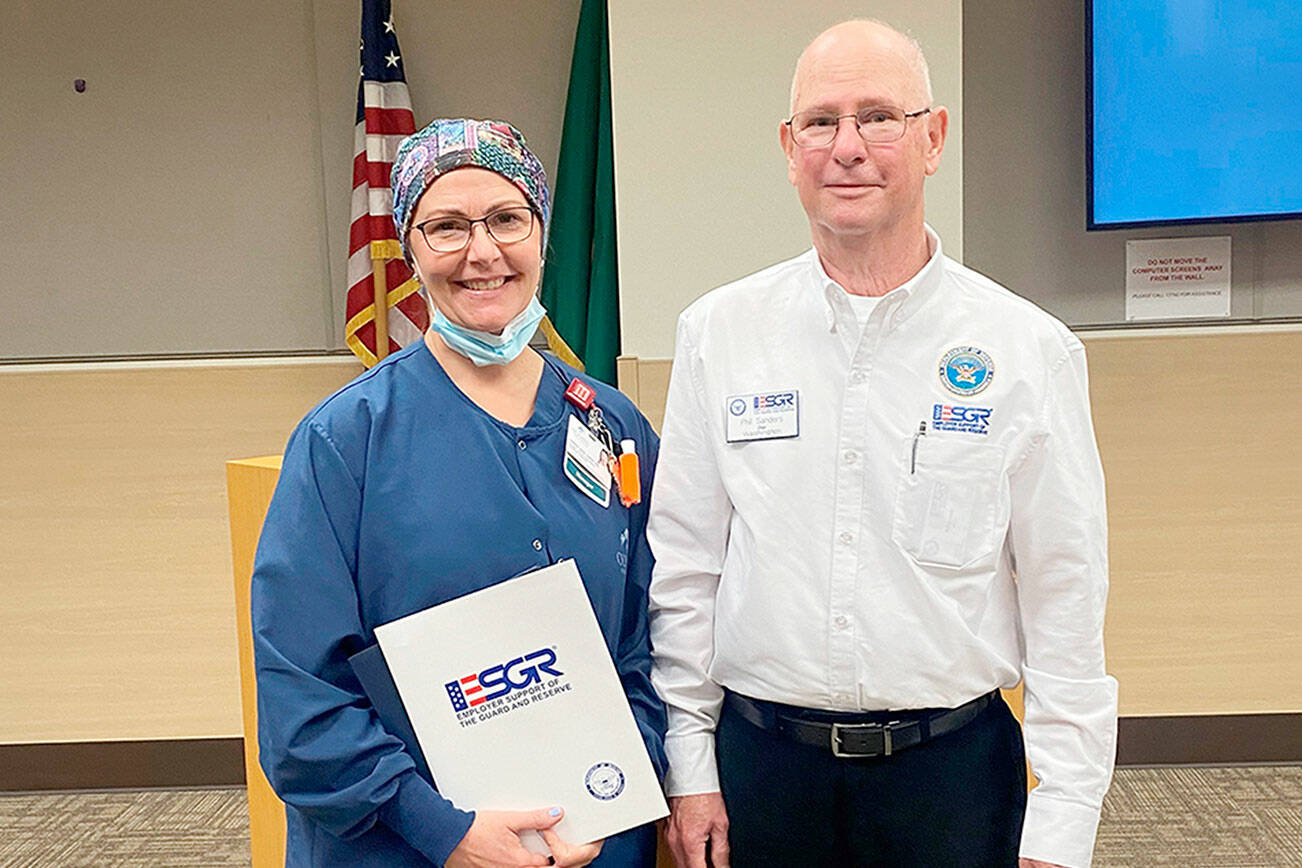 Sarah Winfield, on left, accepts the Patriot Award from Phil Sanders, Washington state chair of the Employer Support of the Guard and Reserve.