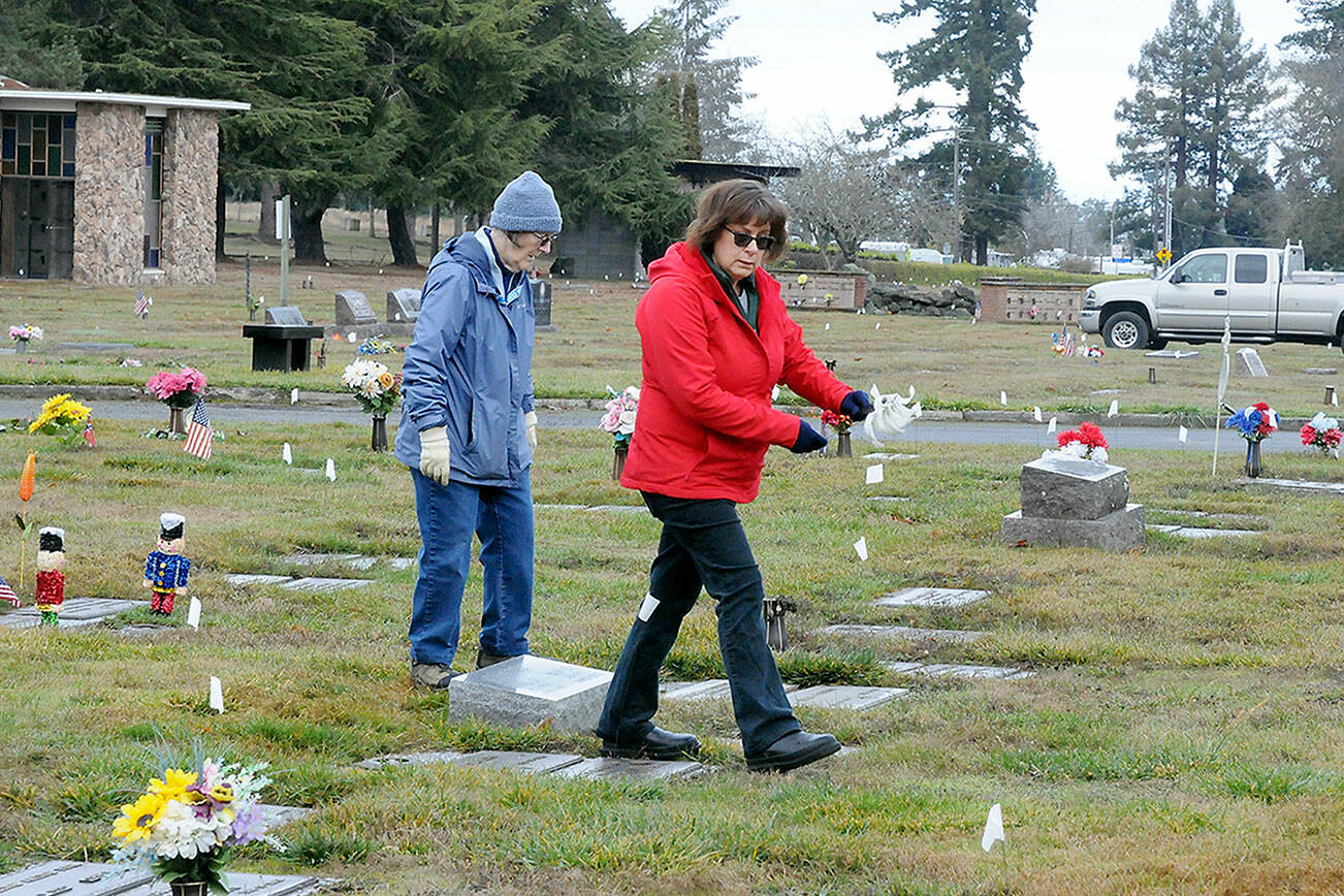 Jan Urfer, left, and Anita Reynolds scout out headstones on Thursday that will receive a wreath for Saturday’s Wreaths Across America ceremony at Mount Angeles Memorial Park in Port Angeles. The women, members of the Michael Trebert Chapter of the Daughters of the American Revolution, were helping prepare for the event, which honors veterans for their service. Around 2,700 sponsored wreaths are planned for placement at Blue Mountain, Dungeness, Gardiner, Sequim View, Mount Angeles and Forks cemeteries, with a formal service planned for 11 a.m. Saturday at Mount Angeles. (Keith Thorpe/Peninsula Daily News)