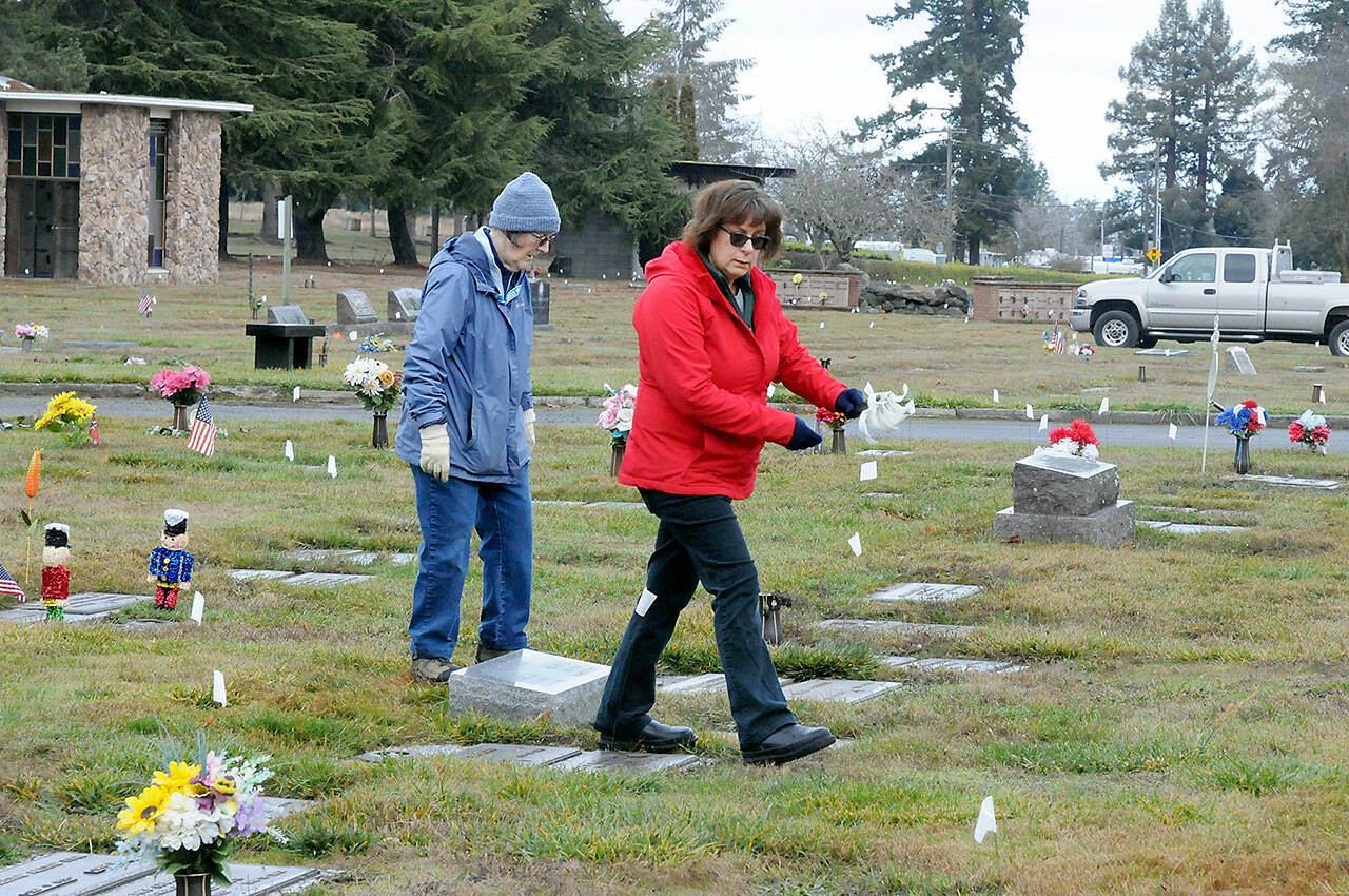 Jan Urfer, left, and Anita Reynolds scout out headstones on Thursday that will receive a wreath for Saturday’s Wreaths Across America ceremony at Mount Angeles Memorial Park in Port Angeles. The women, members of the Michael Trebert Chapter of the Daughters of the American Revolution, were helping prepare for the event, which honors veterans for their service. Around 2,700 sponsored wreaths are planned for placement at Blue Mountain, Dungeness, Gardiner, Sequim View, Mount Angeles and Forks cemeteries, with a formal service planned for 11 a.m. Saturday at Mount Angeles. (Keith Thorpe/Peninsula Daily News)