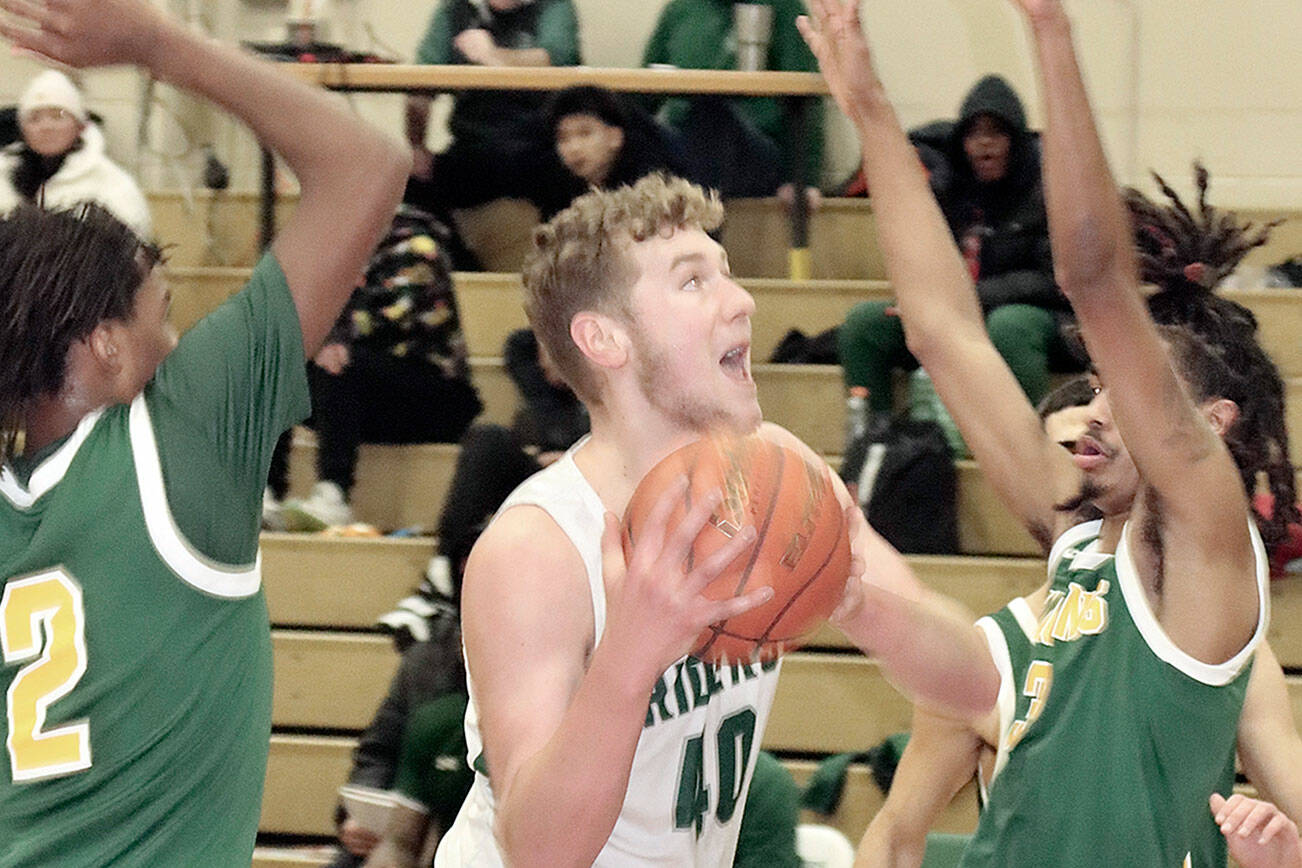 Dave Logan/for Peninsula Daily News
Port Angeles' Isaiah Shamp drives hard to the basket between the hands of Foss defenders last week.