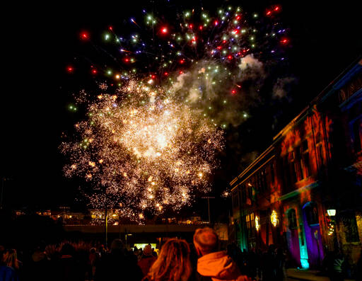 Spectators watch as fireworks explode over Memorial Field in downtown Port Townsend on Saturday night to herald in the new year. The fireworks, set to go off at 9 p.m. to coincide with the Times Square celebration in New York City, were the concluding event of First Night, an all-ages New Year’s Eve event put on by The Production Alliance, a non-profit in Port Townsend. Madison Street, site of city hall on the right, was blocked off so people could watch the display unhindered by traffic. (Steve Mullensky/for Peninsula Daily News)