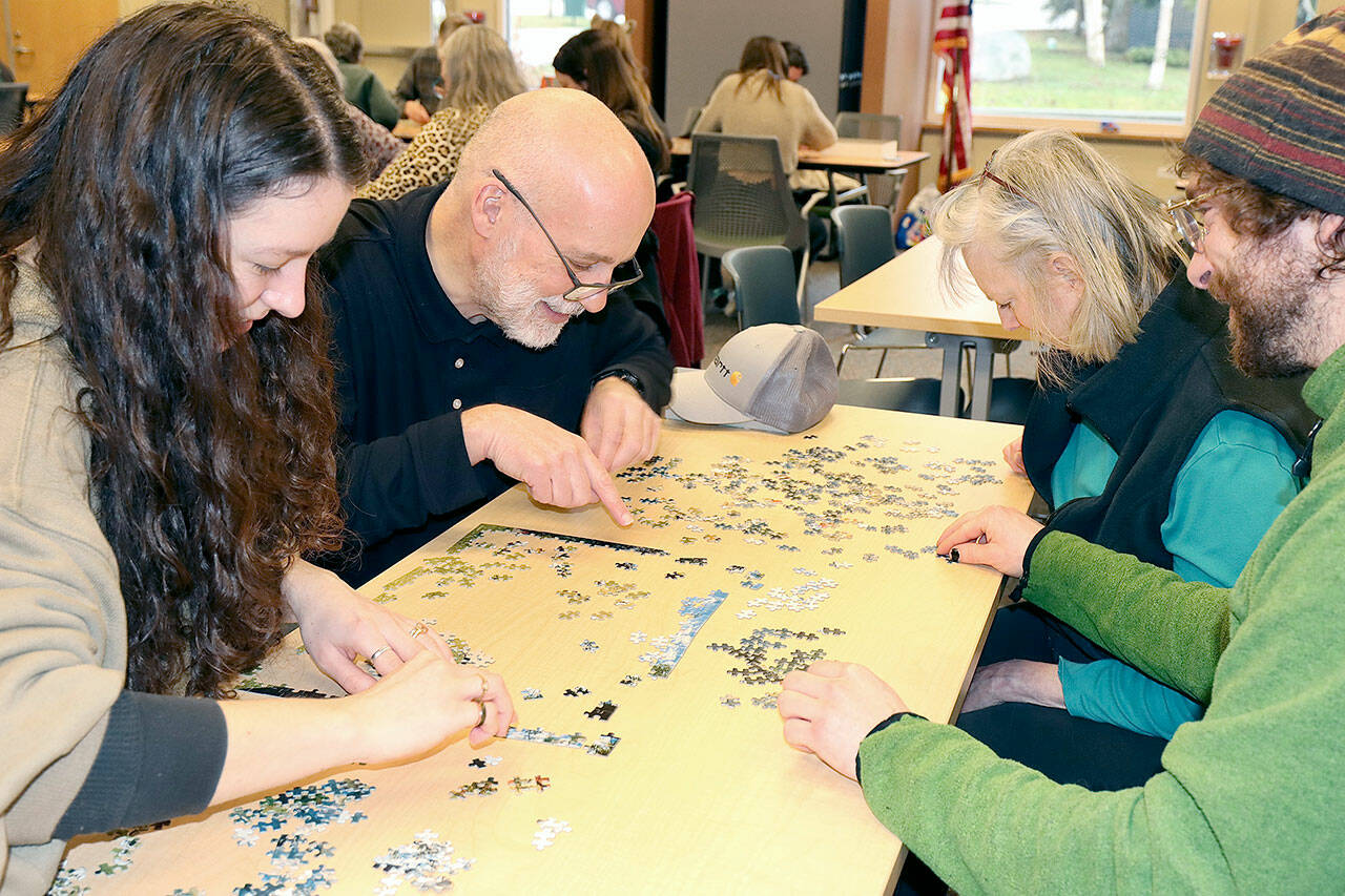 From left, Gabrielle Peterson, Paul Vogel, Kris Vogel and Joe Vogel participate in a jigsaw puzzle contest on Saturday at the North Olympic Library System’s Port Angeles building. Teams had a two-hour limit to put together a 500-piece puzzle, with prizes of gift certificates to Blackbird Coffeehouse on East 8th Street in Port Angeles. Another contest is scheduled for Feb. 11 in the Carver Room of the library. (Dave Logan/for Peninsula Daily News)
