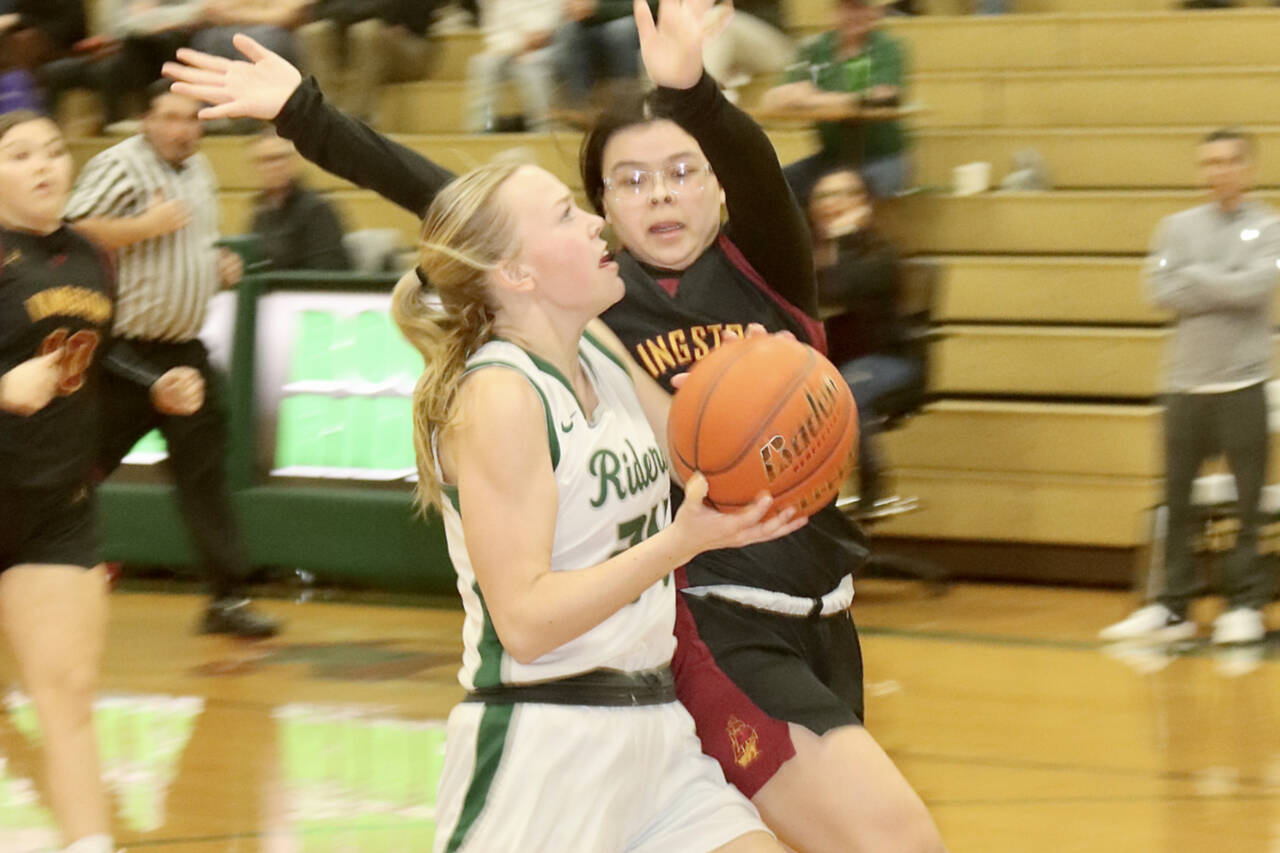 Port Angeles' Anna Petty goes around a Kingston defender in the Roughriders' 55-25 win at home Tuesday night. Petty scored 17 points to lead the Riders. (Dave Logan/for Peninsula Daily News)