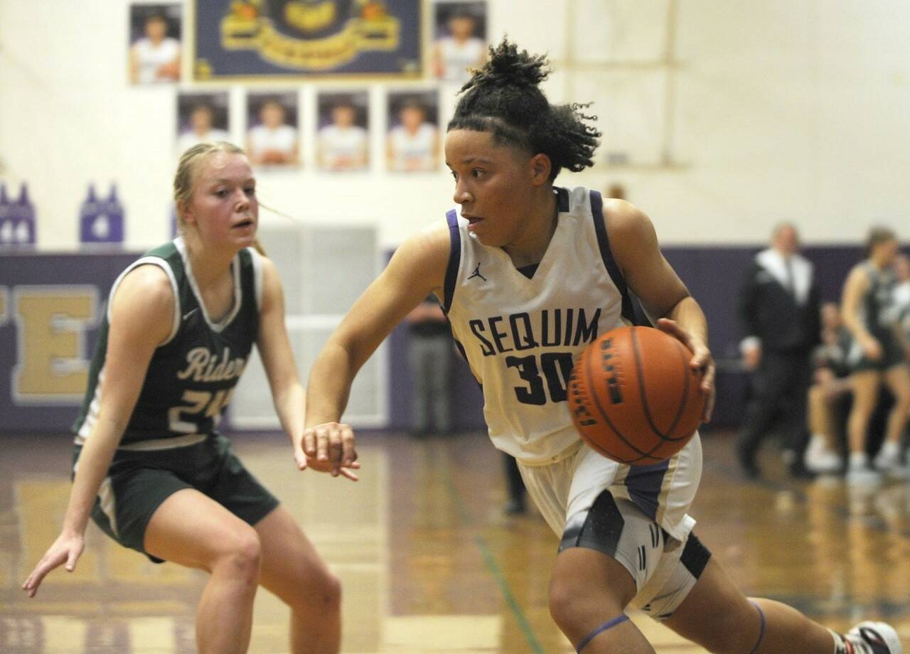Sequim’s Bobbi Mixon drives the ball against Port Angeles’ Anna Petty in Thursday’s game in Sequim. The Wolves won 57-46 thanks to a big third quarter. (Michael Dashiell/Olympic Peninsula News Group)