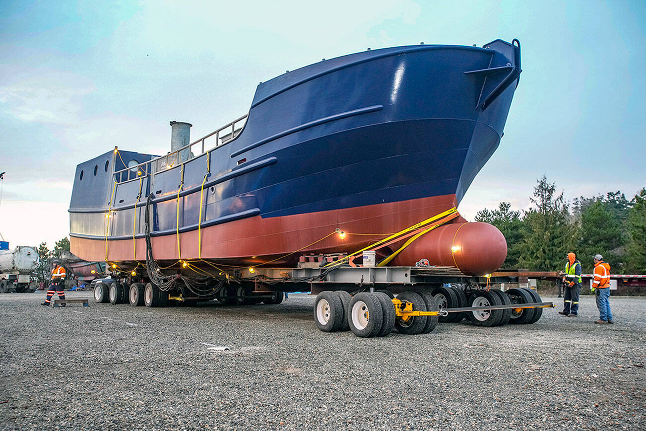 Workers slowly guide a 200-ton, 78-foot-long boat onto a grid, where it will remain for about two months while finishing work is performed. The five-hour move from the 4 Corners area in Jefferson County in the pre-dawn hours on Sunday involved planning and support from various agencies, including the state Department of Transportation, State Patrol and various public utilities, which removed power lines and turned off traffic lights along the route. The boat, which will be named Captain Alaska, according to owner Evan Hall of Bellingham, is a salmon tender and will be working the waters off Alaska. The move was completed by OXBO Mega Transport Solutions from Scappoose, Ore. Planning started about a year ago and the final details took about three months to complete. (Steve Mullensky/for Peninsula Daily News)