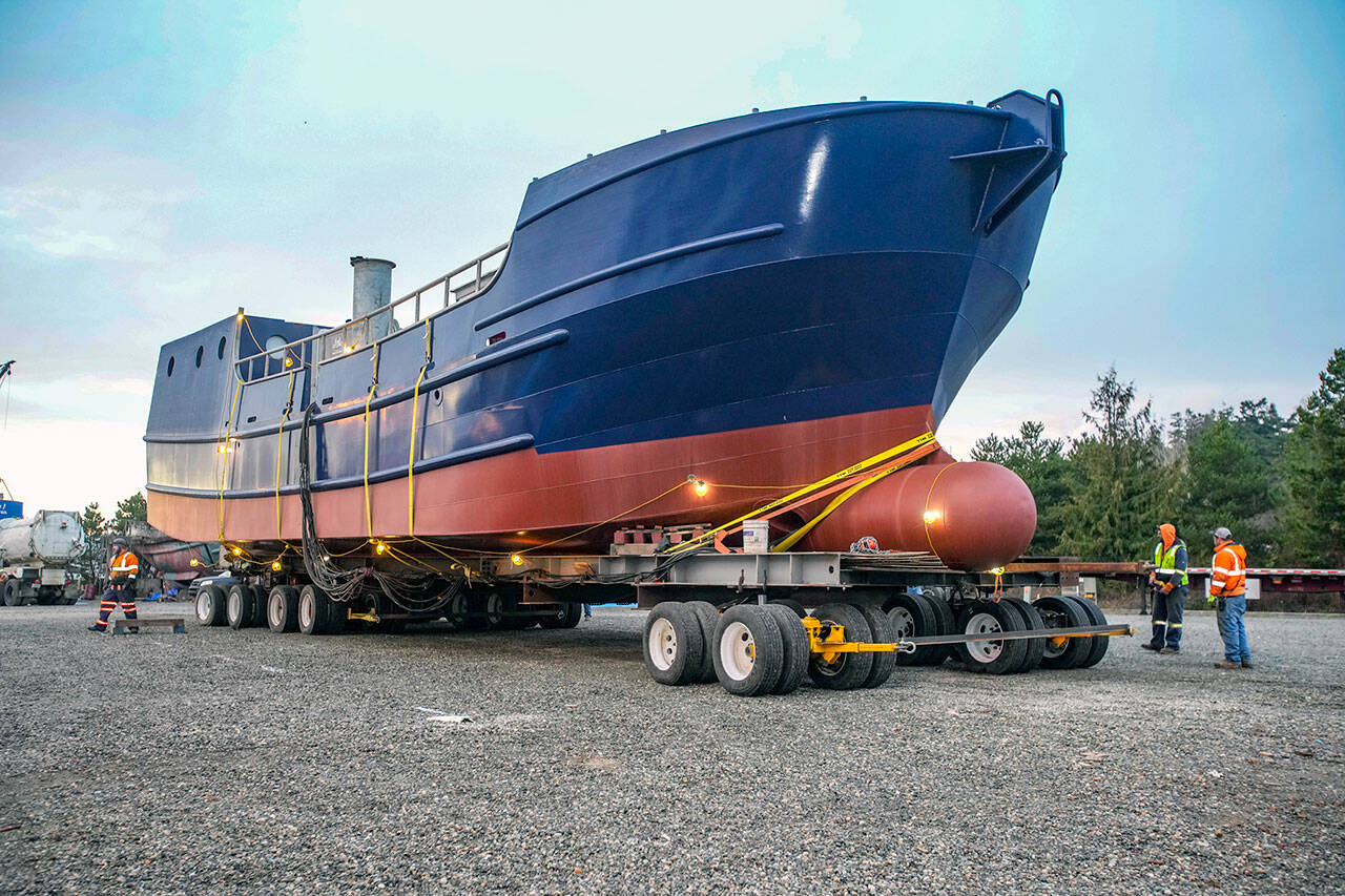 Workers slowly guide a 200-ton, 78-foot-long boat onto a grid, where it will remain for about two months while finishing work is performed. The five-hour move from the 4 Corners area in Jefferson County in the pre-dawn hours on Sunday involved planning and support from various agencies, including the state Department of Transportation, State Patrol and various public utilities, which removed power lines and turned off traffic lights along the route. The boat, which will be named Captain Alaska, according to owner Evan Hall of Bellingham, is a salmon tender and will be working the waters off Alaska. The move was completed by OXBO Mega Transport Solutions from Scappoose, Ore. Planning started about a year ago and the final details took about three months to complete. (Steve Mullensky/for Peninsula Daily News)