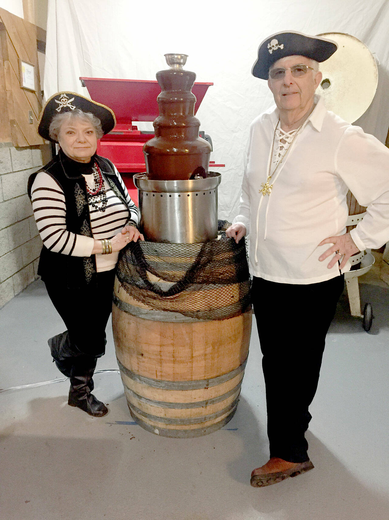 FairWinds Winery owners Judy and Micheal Cavett pose with the chocolate fountain in their pirate-themed Port Townsend Red Wine and Chocolate event.