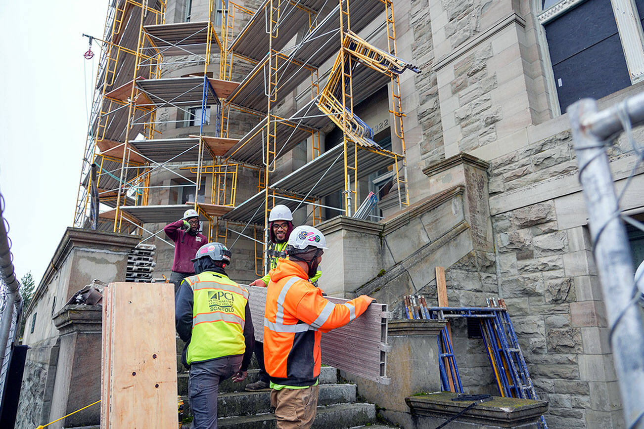 Steve Mullensky/for Peninsula Daily News

Workers for Hilger Construction, out of Tacoma, move parts of scaffolding that will soon encase the historic Post Office and Customs House in Port Townsend. The building, constructed in 1892, is undergoing a months long preservation project to replace aging and nonfunctioning windows.