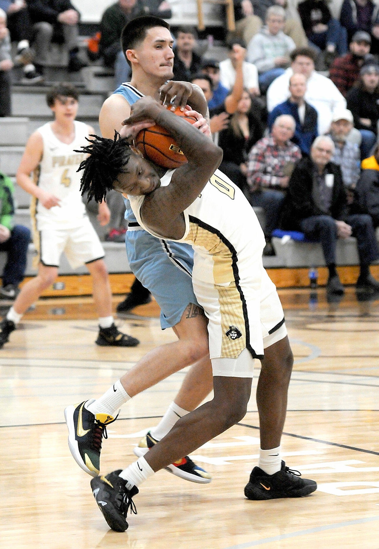 Peninsula’s Ese Onakpoma tries to avoid getting the ball wrestled away by Whatcom’s Chase Calvin on Wednesday in Port Angeles. (Keith Thorpe/Peninsula Daily News)