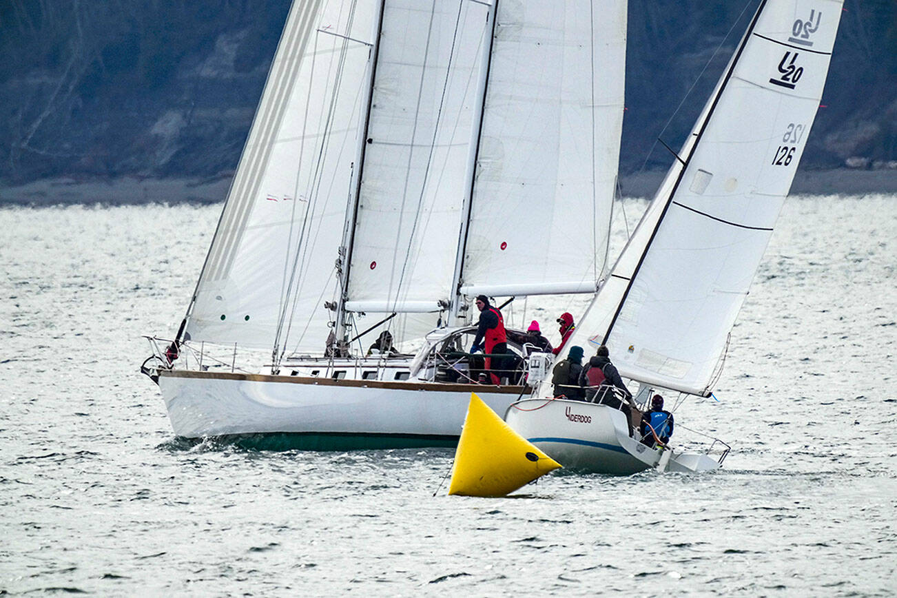 The schooner Sir Isaac rounds a marker with the sloop Underdog on its stern during the 32nd annual Shipwrights Regatta on Port Townsend Bay on Saturday. Twenty-two sailboats were on the water for the noon start. The regatta, hosted by the Port Townsend Sailing Association and supported by the Northwest Maritime Center, marks the beginning of the sailboat racing season in Port Townsend. (Steve Mullensky/for Peninsula Daily News)