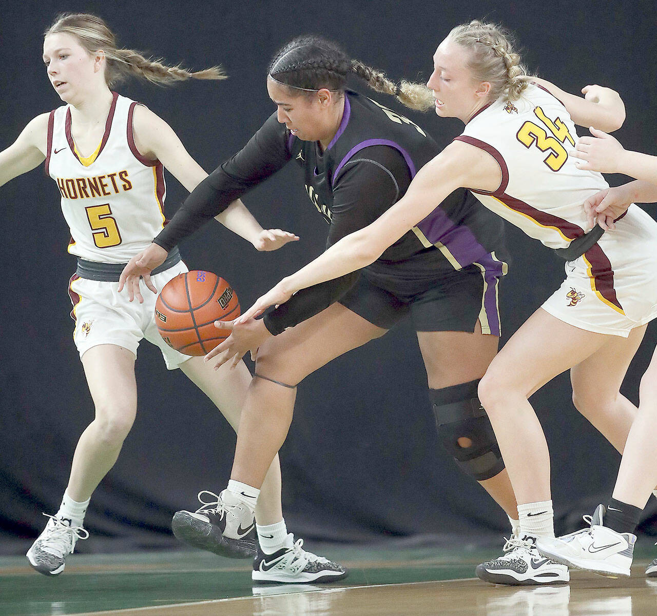 David Willoughby/for Peninsula Daily News Sequim’s Jelissa Julmist, center, competes for a loose ball with White River’s Sophie Ross-Soler, left, and Vivian Kingston during the Wolves’ Class 2A state quarterfinal at the Yakima SunDome on Thursday night.