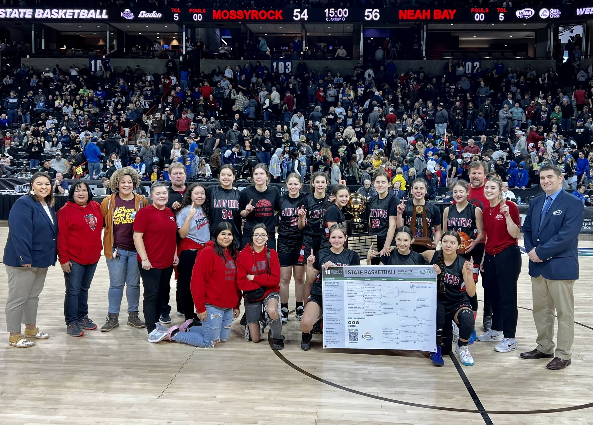 The Neah Bay girls basketball team celebrates winning the 1B state championship Saturday night in Spokane. (Bridget Mayfield/for the Peninsula Daily News)