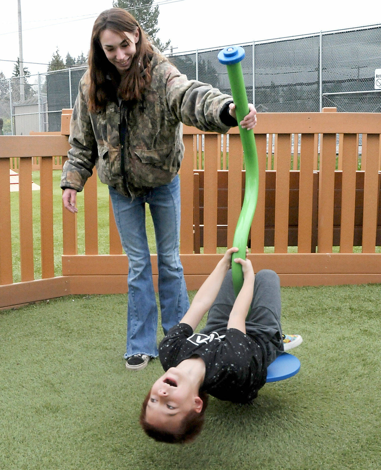 Maxamus White, 8, laughs with delight as his mother, Naomi White of Port Angeles, twirls him around on a spin toy on Saturday at the Dream Playground at Erickson Playfield in Port Angeles. The pair were enjoying a break in the weather before showers moved into the area. (Keith Thorpe/Peninsula Daily News)