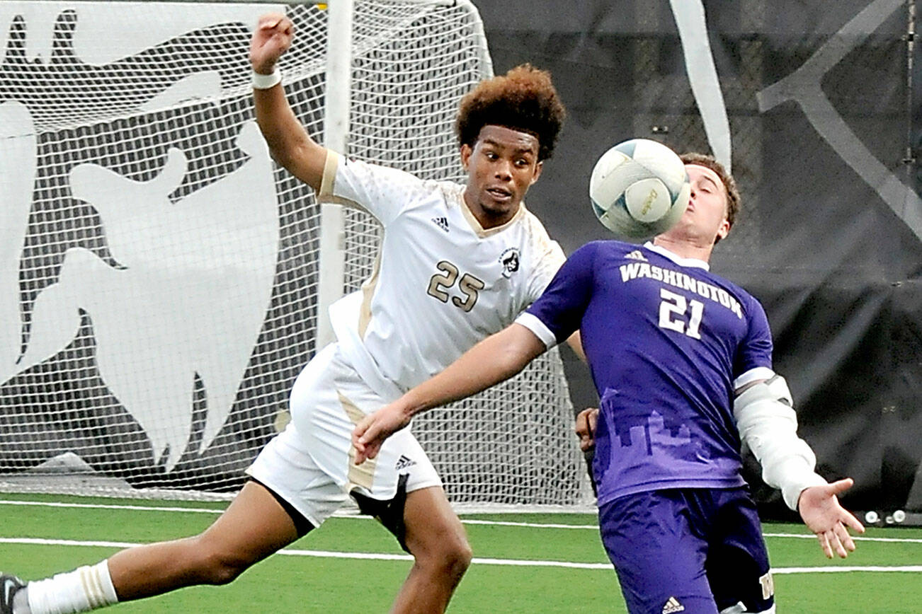 KEITH THORPE/PENINSULA DAILY NEWS
Peninsula's Taffel McCootie, left, and the University of Washington's Charlie Kosakoff compete for a loose ball on Saturday at Sigmar Field in Port Angeles.