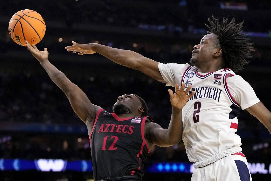 Connecticut guard Tristen Newton blocks a shot by San Diego State guard Darrion Trammell during the second half of the men’s national championship college basketball game in the NCAA Tournament on Monday in Houston. (AP Photo/David J. Phillip)