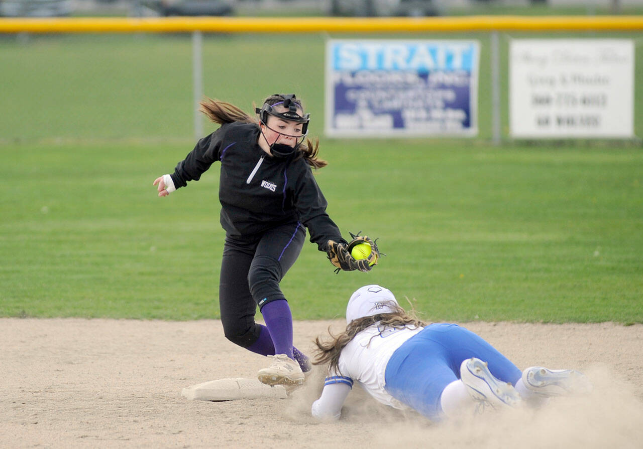 Michael Dashiell/Olympic Peninsula News Group Sequim shortstop Hannah Bates, left, puts the tag on an Olympic runner in an April 13 league match-up in Sequim.