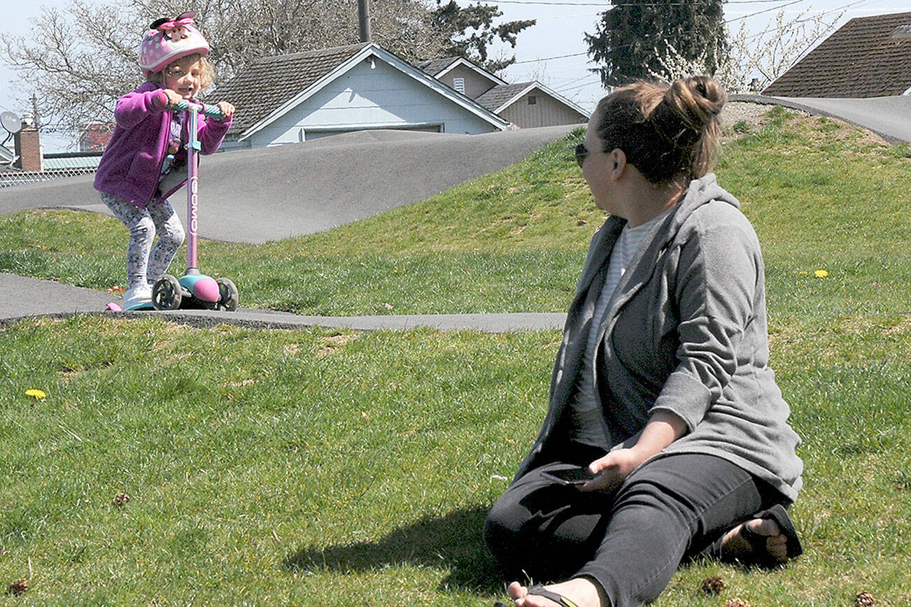 Ellori Rotter, 3, of Port Angeles scoots around the Port Angeles Pump Track at Erickson Playfield in Port Angeles as her aunt, Alison Schmidt of Marysville, keeps watch on Thursday. In a break from a spring of below-average temperatures, several days of seasonable temperatures are forecast for most of Western Washington through the weekend.