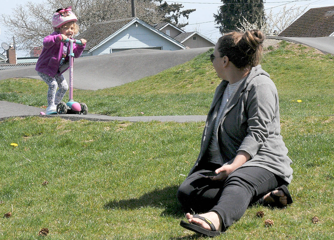 Ellori Rotter, 3, of Port Angeles scoots around the Port Angeles Pump Track at Erickson Playfield in Port Angeles as her aunt, Alison Schmidt of Marysville, keeps watch on Thursday.