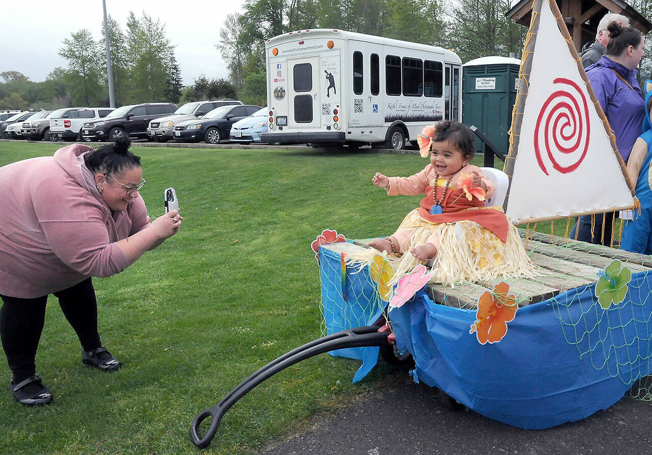 Lesley Welch of Sequim takes a photo of her daughter, Avani Welch, 1, on a Moana-themed mini float during Saturday’s Irrigation Festival Kids Parade at the Haller Athletic Fields in Sequim. The float was awarded grand prize by the judges, taking top honors in the parade. (Keith Thorpe/Peninsula Daily News)