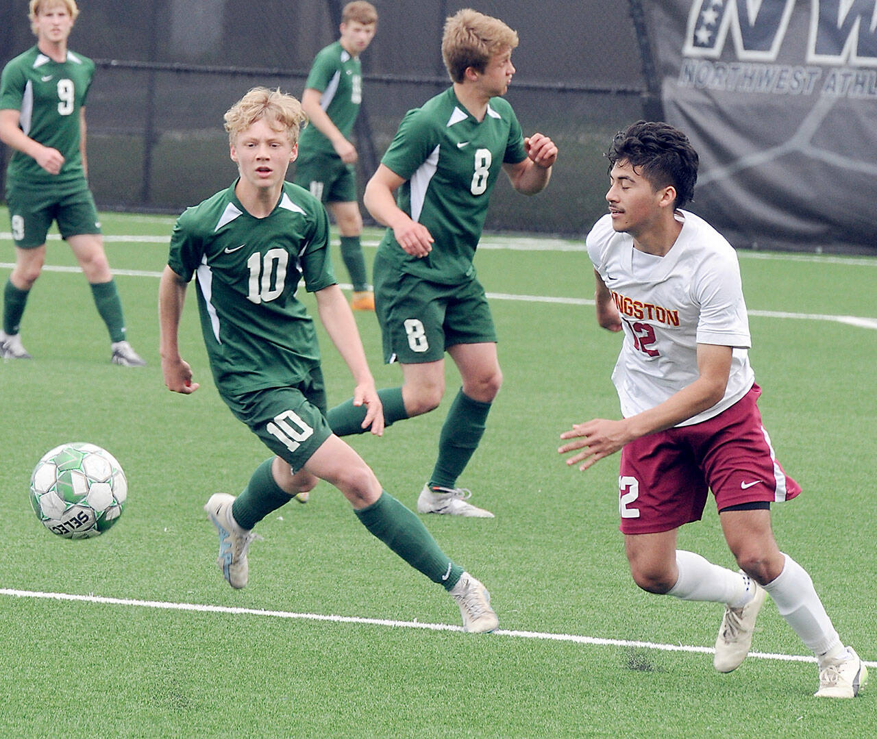 Port Angeles’ Matthew Miller, left, chases a loose ball ahead of Kingston’s Edwin Vallecillo, right, as Miller’s teammates, from left, Hannes Spieker, Kaleb Gagnon and Jacob Miller watch from the backfield during Saturday’s match in Port Angeles. (Keith Thorpe/Peninsula Daily News)