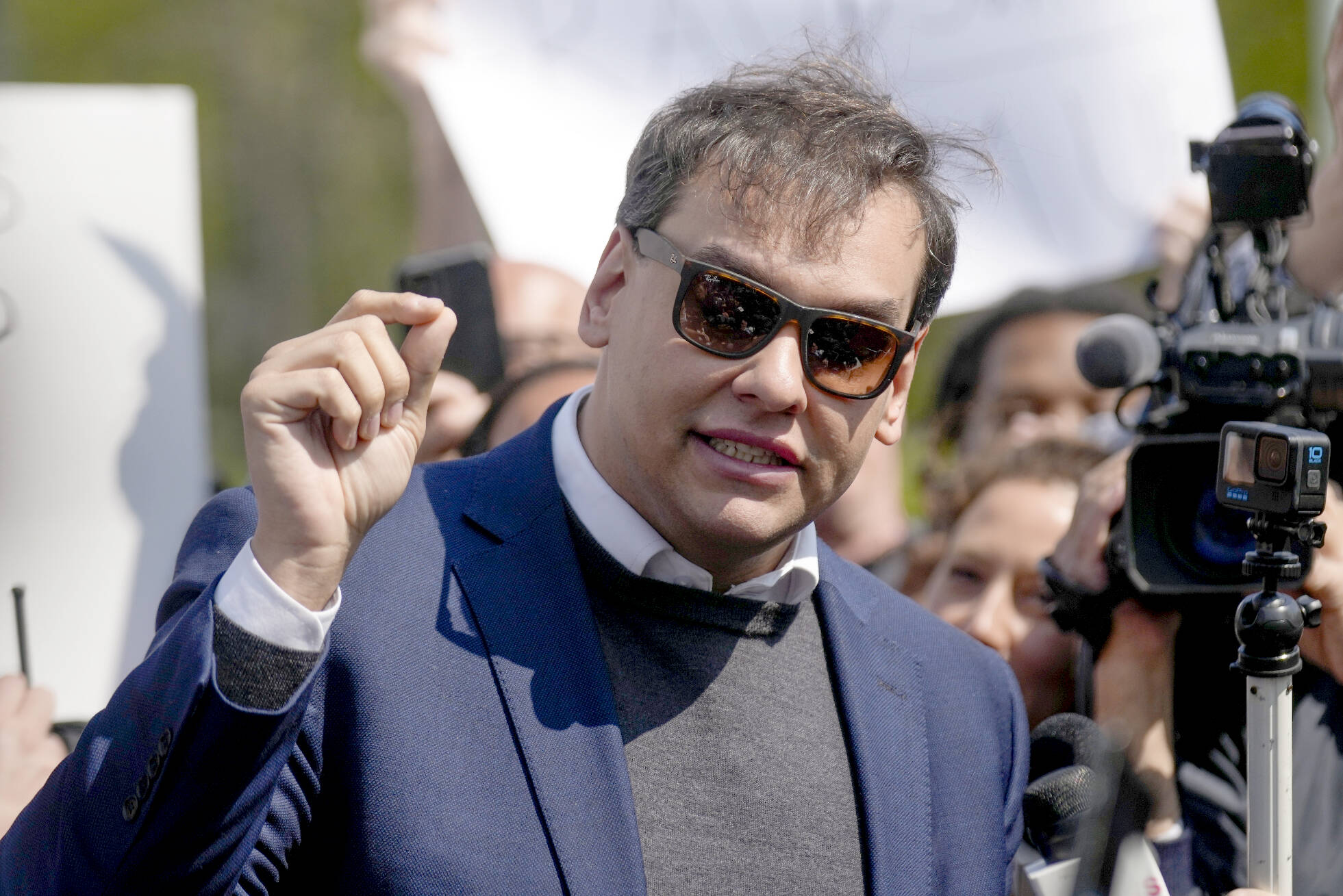 U.S. Rep. George Santos, R-N.Y., speaks to the media outside the federal courthouse in Central Islip, N.Y., Wednesday May 10, 2023.  On Friday, May 12,  The Associated Press reported on stories circulating online incorrectly claiming an image of Santos in a gray sweater and blue jacket is a mugshot taken Wednesday after he was indicted on federal charges.(AP Photo/Seth Wenig)