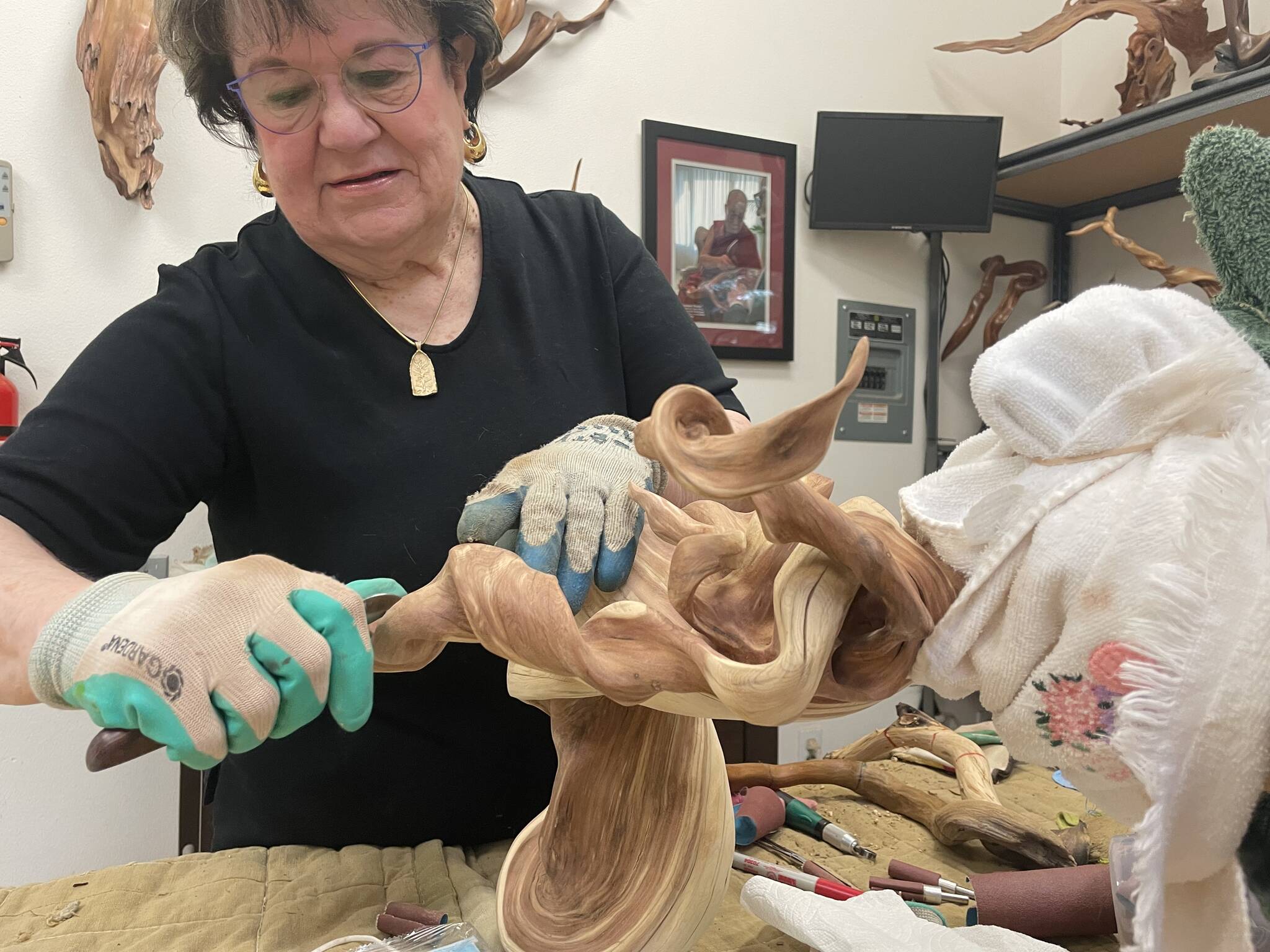 Driftwood art instructor Tuttie Peetz works on a driftwood art piece at her home studio for Olympic Driftwood Sculptors’ next show Saturday and Sunday at the Dungeness River Nature Center. She said she’s put in more than 1,000 hours into shaping the twisted juniper wood from Montana. (Matthew Nash/Olympic Peninsula News Group)