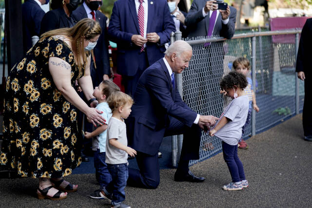 FILE - President Joe Biden greets children as he visits the Capitol Child Development Center, Friday, Oct. 15, 2021, in Hartford, Conn.  On Friday, May 19, 2023, The Associated Press reported on a photo circulating online that was manipulated to make it appear that Biden was touching a child inappropriately below the waist.   (AP Photo/Evan Vucci, File)
