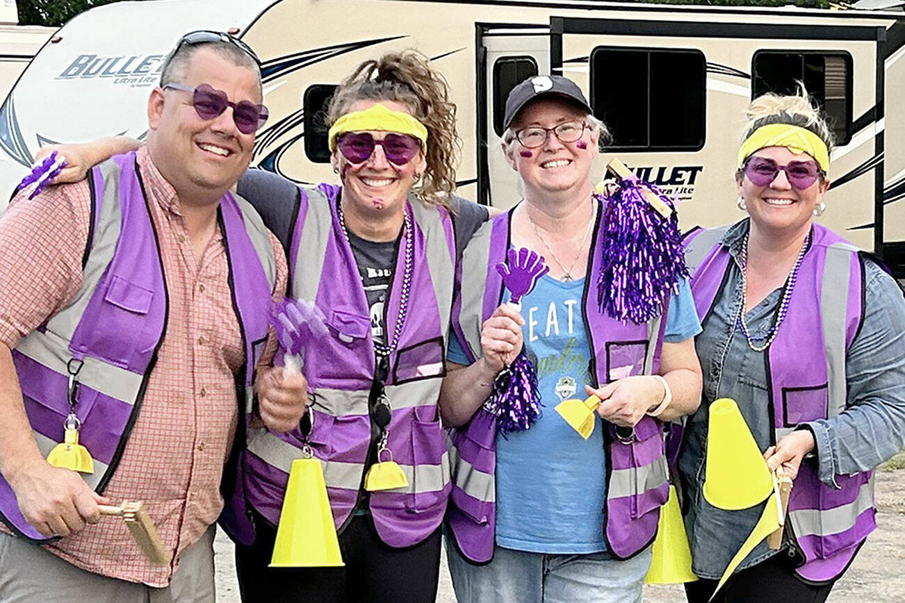 Cutline: Sequim parents cheered the team on wearing their fan vests made by mom Anna Swanberg. Bryan Swanberg, left, Anna, Christie Sharpe, and Misty Gilbertson