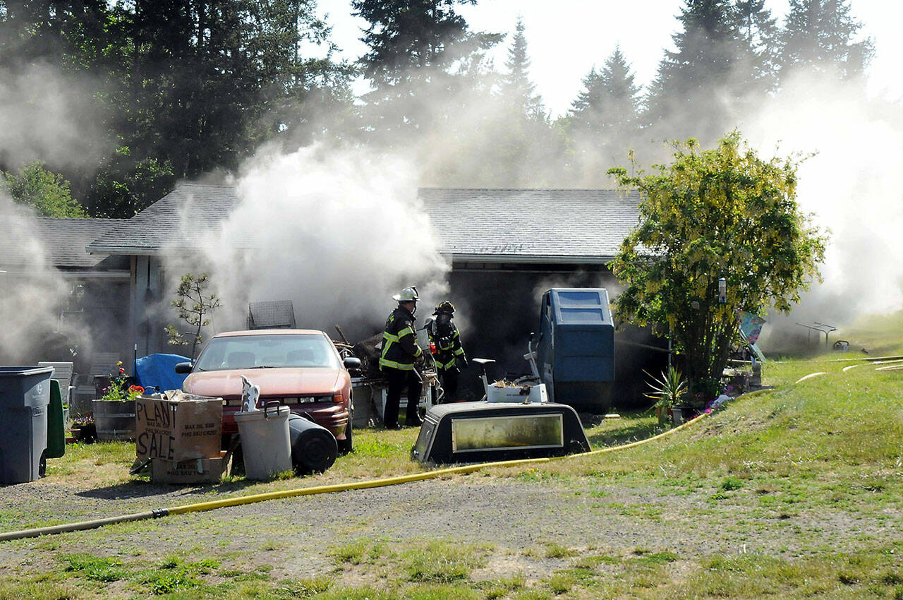 Smoke billows from a garage 71 S. Benson Road near Port Angeles on Wednesday. (Keith Thorpe/Peninsula Daily News)