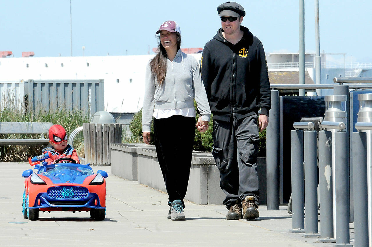 Goby McCaffrey, 3, does his best Spiderman act in his battery-powered Spider-Mobile with his parents, Teresa and Travis McCaffrey of Port Angeles, while strolling the Esplanade on the Port Angeles waterfront on Wednesday. The family was on a springtime stroll and the youngster had insisted on superhero regalia. (Keith Thorpe/Peninsula Daily News)