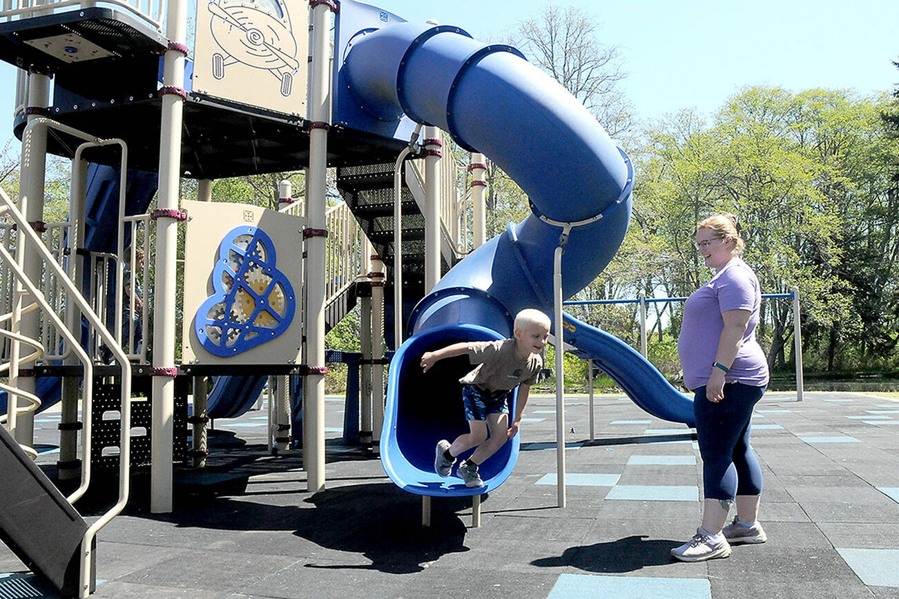 KEITH THORPE/PENINSULA DAILY NEWS
Four-year-old Collin Windrich bolts from a slide on the playground at Shane Park in Port Angeles as his mother, Lissa Windrich of Sequim, watches on Tuesday. The playground equipment was reopened on Monday after being closed by the Port Angeles Parks Department in September 2022 after numerous tiles on the play surface became dislodged, creating a trip hazard for playground users. Delays ensued acquiring specialized glue and replacement tiles while waiting for adequate weather to complete the project.