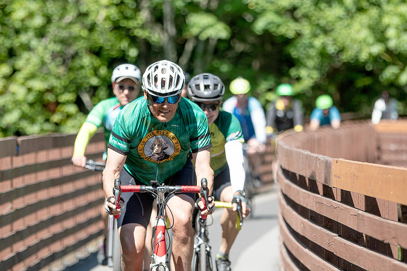 Gov. Jay Inslee rides across the Johnson Creek Railroad Trestle Foot Bridge on the Olympic Discovery Trail east of Sequim on Wednesday. The Rails-to-Trails Conservancy honored Inslee as its 2023 Rail-Trail champion during an event at Red Cedar Hall in Blyn following Inslee's 27-mile ride from Port Angeles. (Jesse Major/Rails-to-Trails Conservancy)