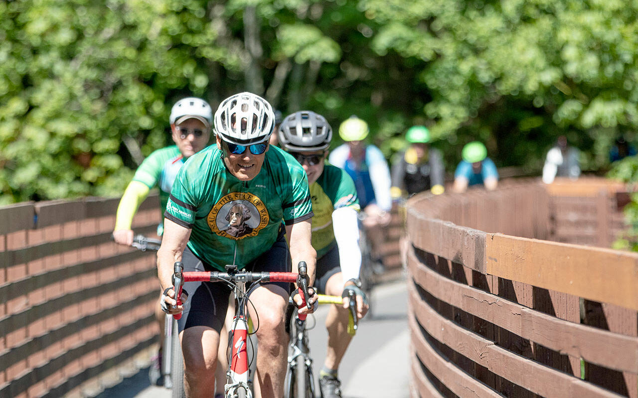 Gov. Jay Inslee rides across the Johnson Creek Railroad Trestle Foot Bridge on the Olympic Discovery Trail east of Sequim on Wednesday. The Rails-to-Trails Conservancy honored Inslee as its 2023 Rail-Trail champion during an event at Red Cedar Hall in Blyn following Inslee’s 27-mile ride from Port Angeles. (Jesse Major/Rails-to-Trails Conservancy)