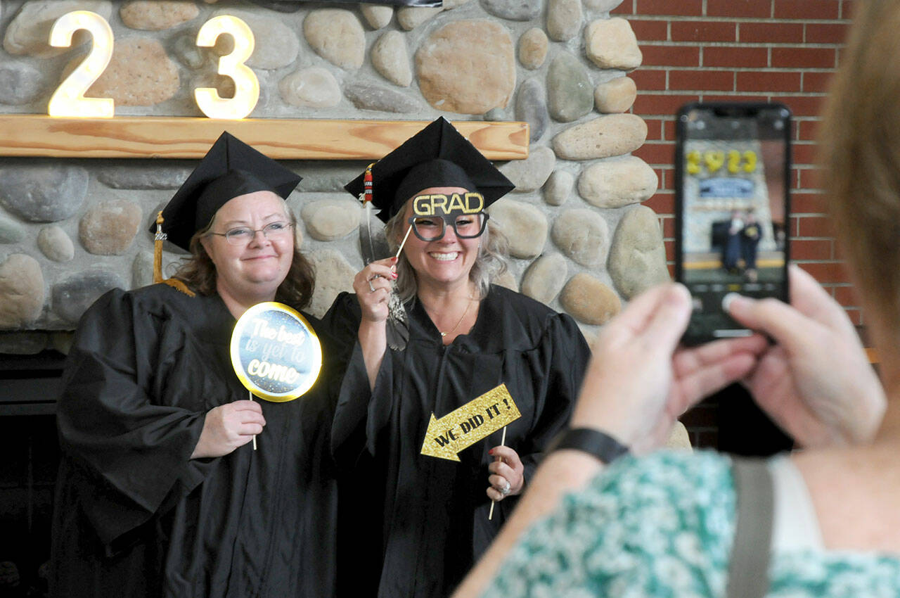 Peninsula College graduates April Fordyce-Blewett, left, and Deborah Ceja-Cisneros, both of Forks, have a photograph taken by Fordyce-Blewett’s mother, Peggy Blewett, prior to the first of two commencement ceremonies on Saturday on the college’s Port Angeles campus. A total of 388 degrees and certificates were awarded for the 2022-23 school year with 270 people signed up to participate Saturday’s ceremonies. (Keith Thorpe/Peninsula Daily News)