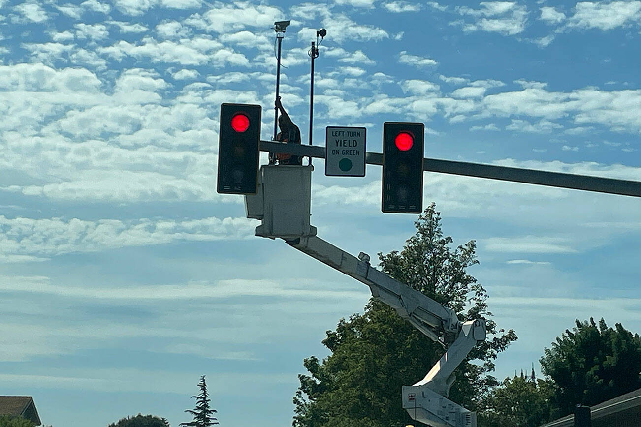 Staff with subcontractor GG Electric install radio and camera equipment at the North Fifth Avenue and Fir Street intersection to help traffic flow there and at seven signals across the City of Sequim. Work is anticipated to be completed by contractor Western Systems in early July, according to city staff. (Matthew Nash/Olympic Peninsula News Group)
