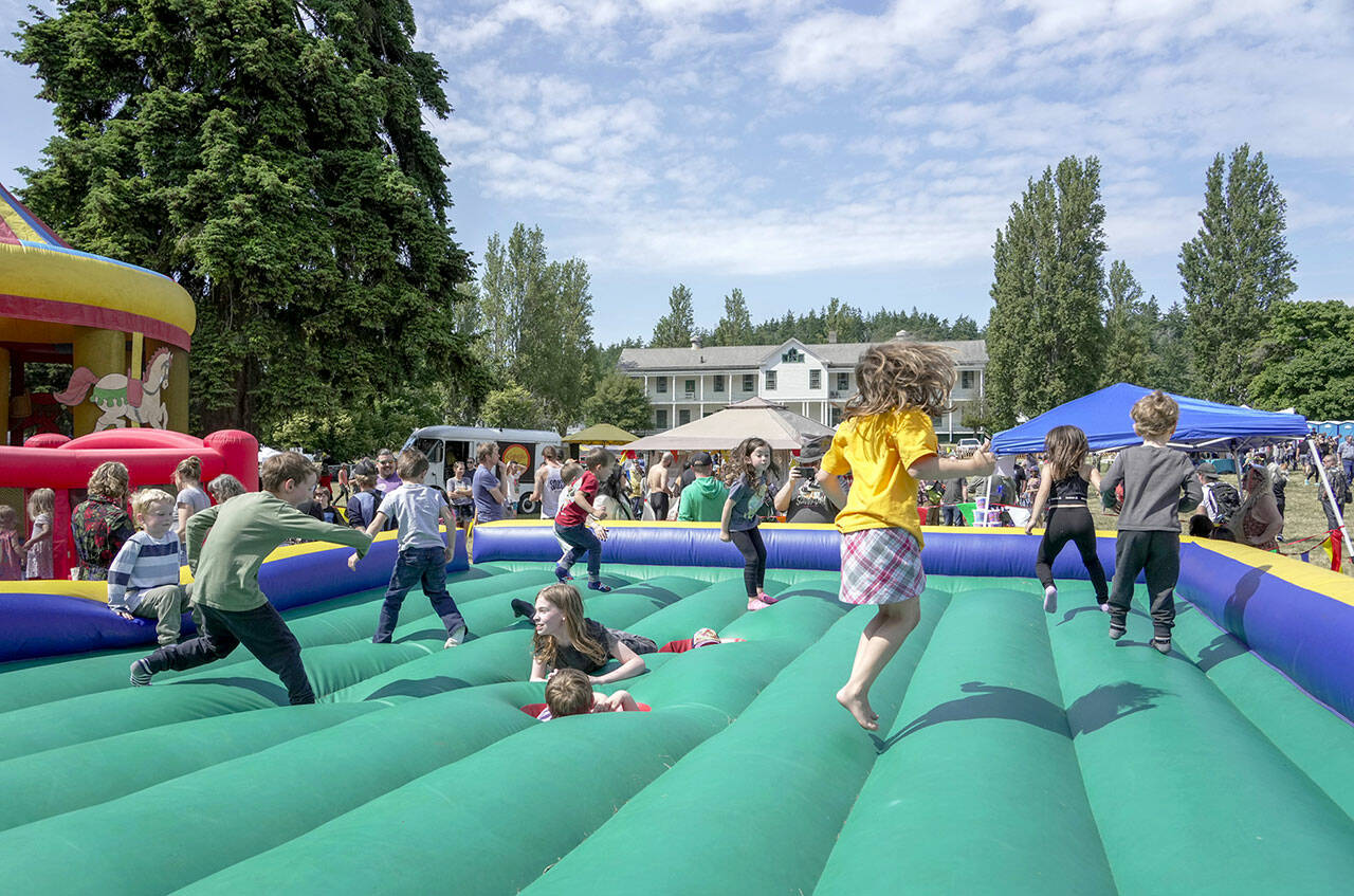 Kids get a kick out of the bouncy jumper at the free Field Day event at Fort Worden State Park on Saturday. The event included a range of games, prizes and live entertainment presented by The Production Alliance and Fort Worden Hospitality. (Steve Mullensky/for Peninsula Daily News)