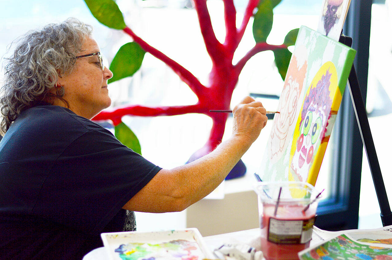 Virginia Ashby spent the afternoon of June 23 painting at Grover Gallery in Port Townsend, where her art is part of the “Psychedelic Summer” exhibition. (photo courtesy of Northwind Art)