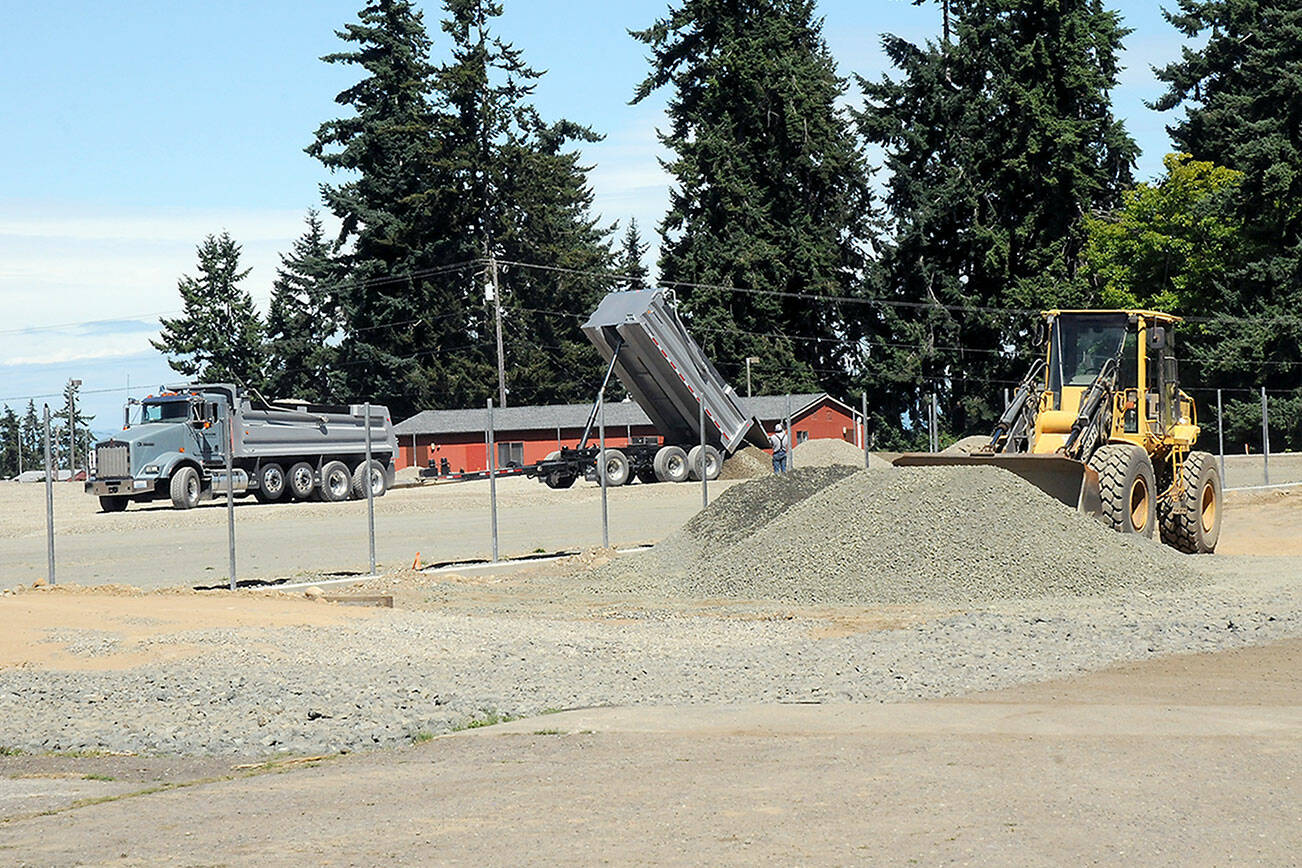 A tandem dump truck delivers sub-surface material on Wednesday at the site of the future Monroe Playfield at Roosevelt School in Port Angeles. (Keith Thorpe/Peninsula Daily News)