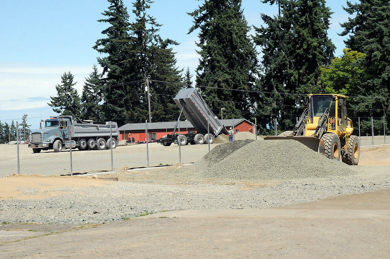 A tandem dump truck delivers sub-surface material on Wednesday at the site of the future Monroe Playfield at Roosevelt School in Port Angeles. (Keith Thorpe/Peninsula Daily News)