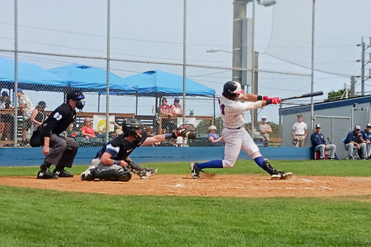 Port Angeles' Julio Vasquez hits a fly ball in the second inning Sunday against the Bellingham Bells at Civic Field in Port Angeles. (Pierre LaBossiere/Peninsula Daily News)