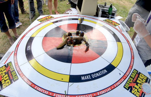 Race official Erin Bertleson, right, of Joyce watches with clenched fists as Seattle Spew and Slug-o-War jostle for the finish line. All proceeds benefit Clallam County Fire District No. 4 in Joyce. (Sam Nugent)