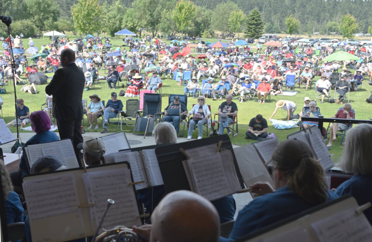 A summer crowd settles in as Sequim City Band members and director Tyler Benedict prepare to play during the opening announcement of the Fourth of July concert. (Richard Greenway/Sequim City Band)