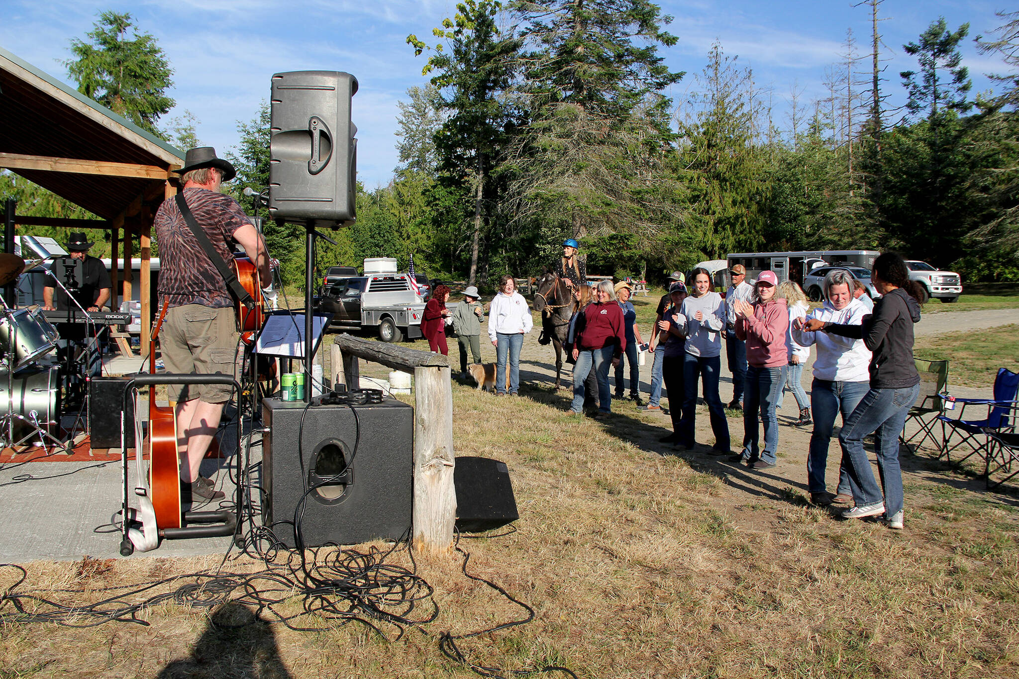 Carrie Kirksey (gray sweatshirt, front left) and Raquel Edwards (far right) had fun learning some new dance moves while listening to local band JFA during OPEN’s annual fundraiser at Sequim’s Layton Hill Horse Camp. The two traveled from Snohomish to support the event after Kirksey adopted her horse Missy from OPEN. Thanks to generous donations OPEN reached its goal of raising enough money to fill its barn with another year’s worth of hay. (Karen Griffiths/For Peninsula Daily News)