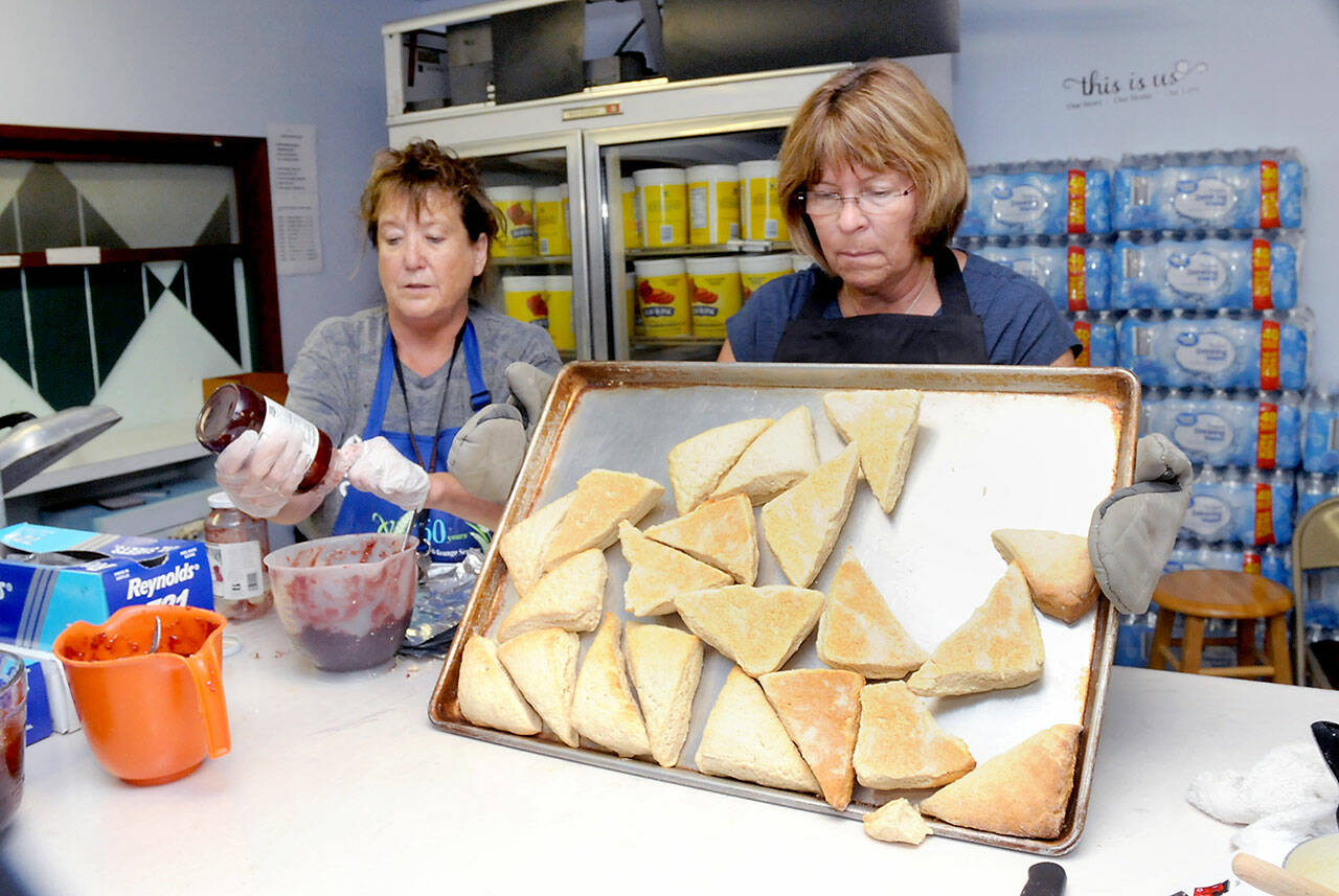 “Jammers” Cindy Kelly, left, and Shelly Romero prepare freshly baked scones for distribution on Wednesday in the scone kitchen at the Clallam County Fairgrounds. (Keith Thorpe/Peninsula Daily News)