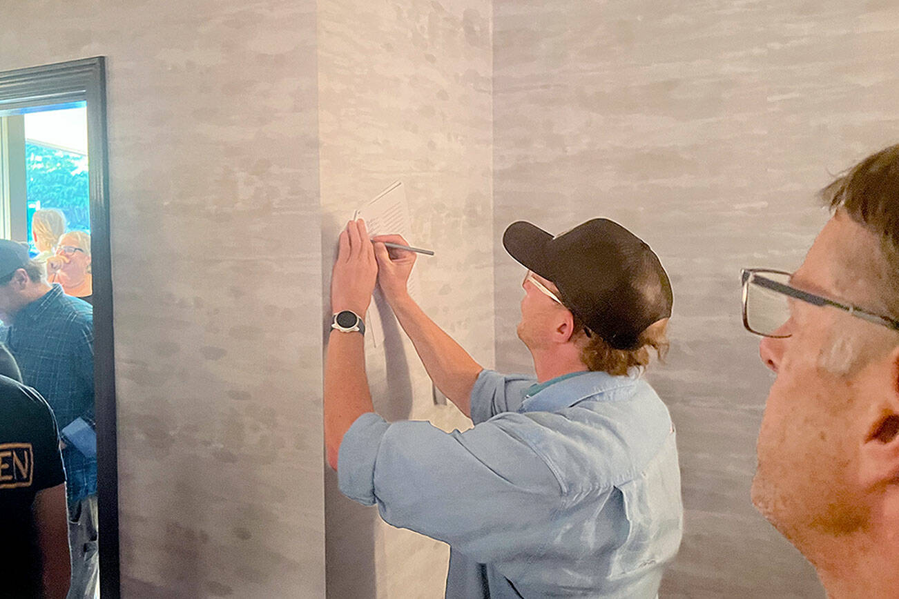 Eric Coufal signs a letter urging Olympic National Park officials to ensure access to Hurricane Ridge this winter. Locals have been concerned about winter access after the ridge’s day lodge burned down in May. A local coalition held a meeting at the Red Lion Hotel in Port Angeles on Wednesday to discuss the situation. (Peter Segall/Peninsula Daily News)